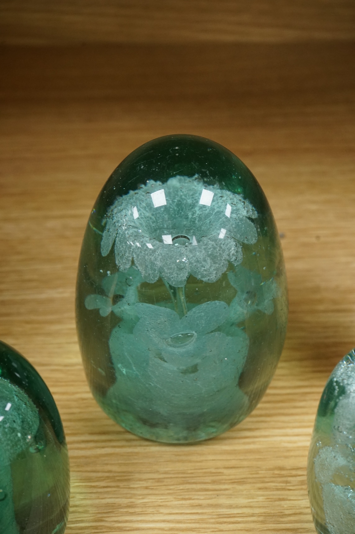 Three Victorian green glass dump weights, largest 14cm high